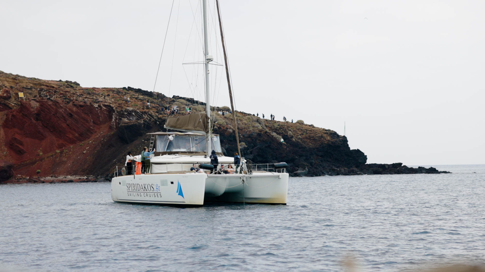 catamaran sailing along coastal cliffs filmed for tourism brand video production campaign