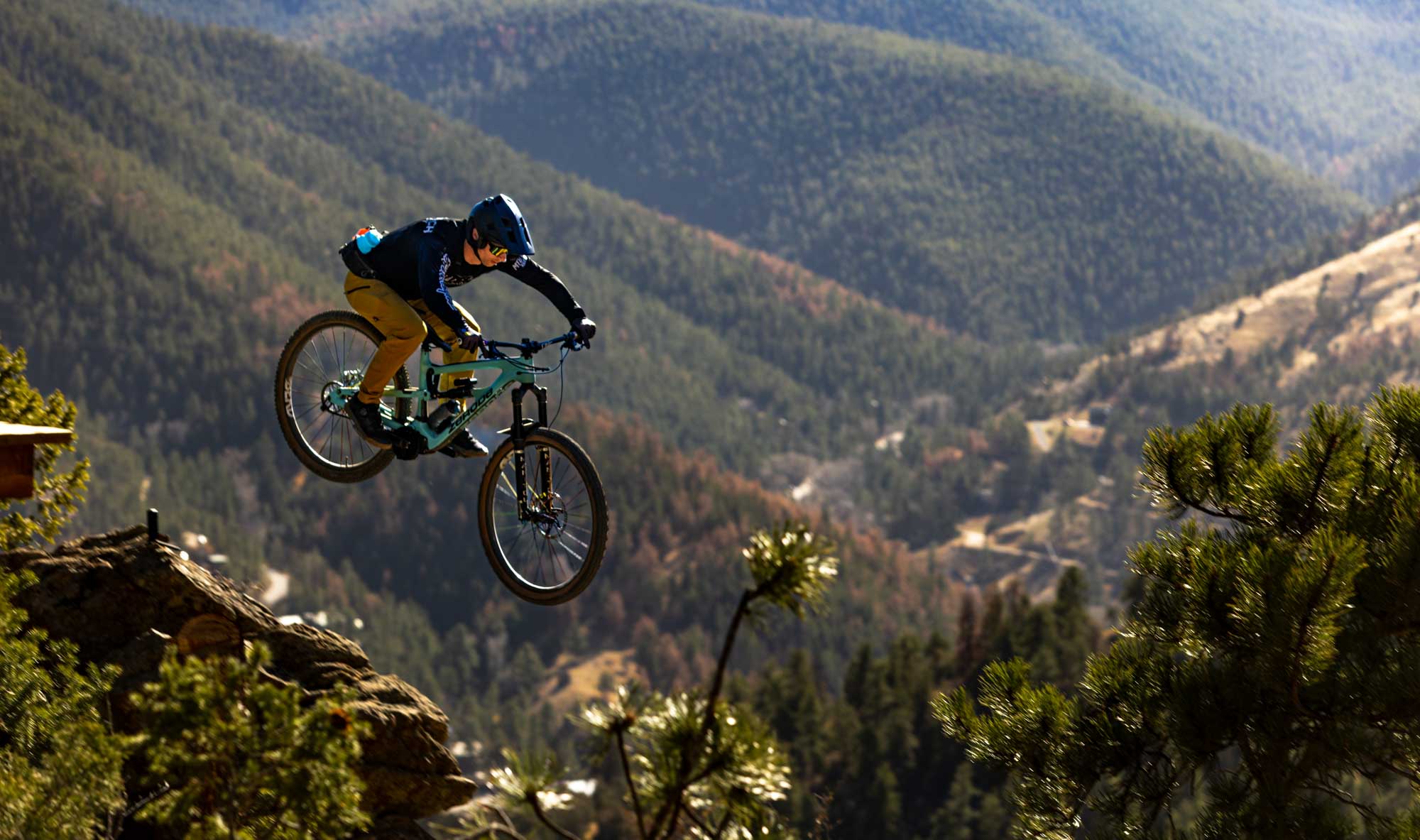 mountain biker jumping off cliff in alpine terrain filmed for outdoor brand film production
