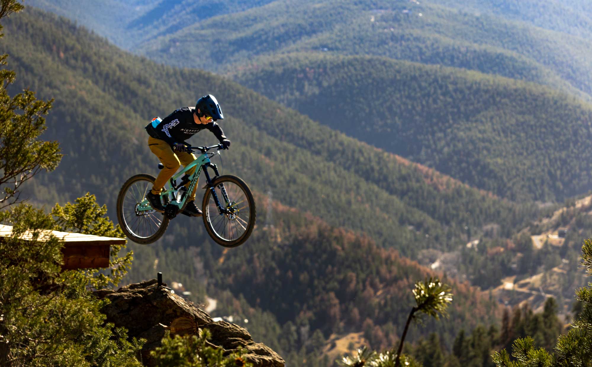 mountain biker jumping off cliff in alpine terrain filmed for outdoor brand video production