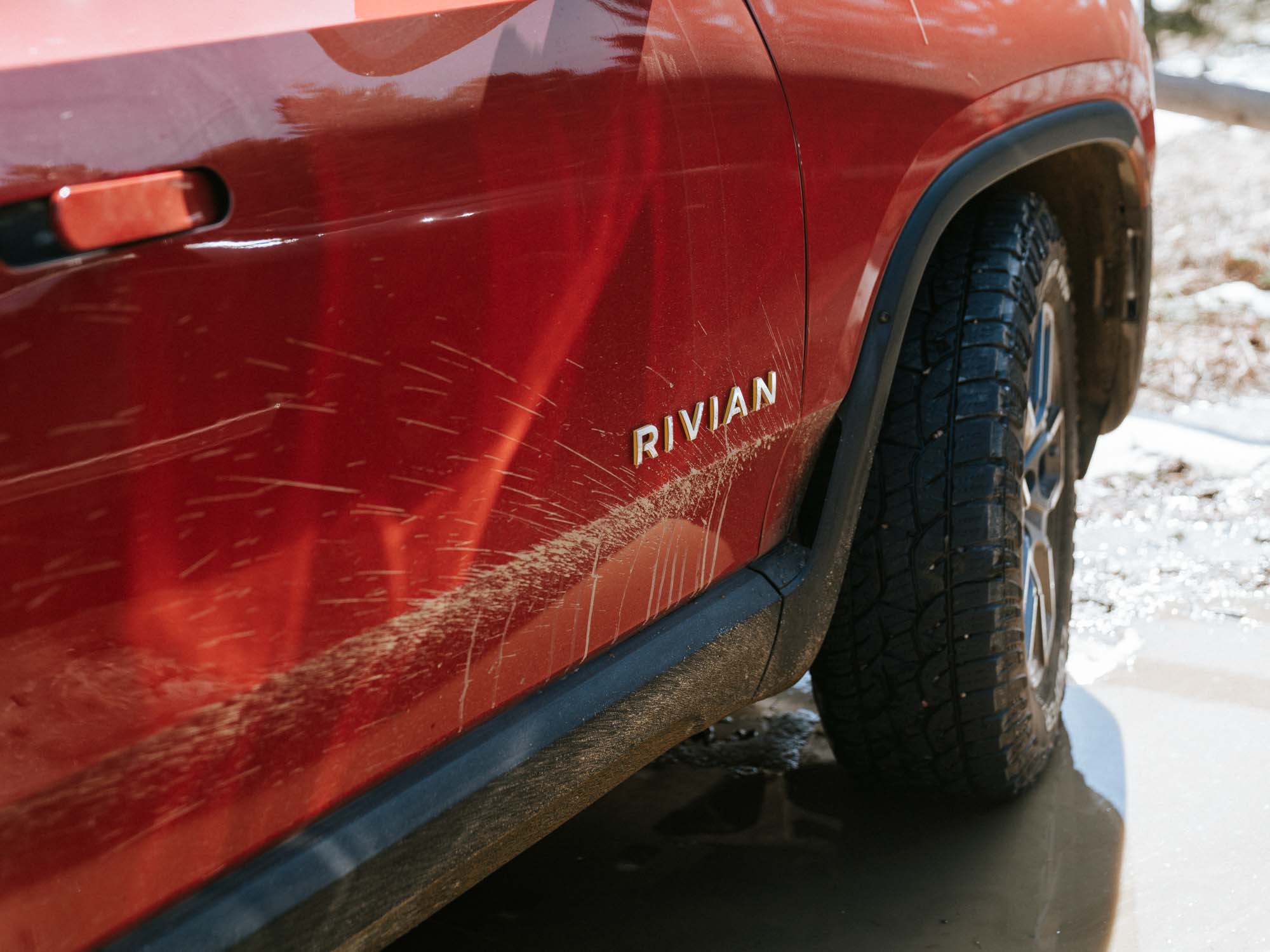 close up of electric truck wheel and body driving through snow filmed for automotive video production in Colorado